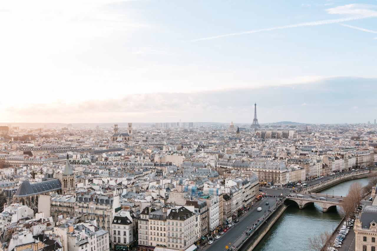 Aerial view of Paris rooftops at sunset with the Eiffel Tower and the Seine river